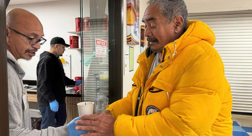 homeless man receiving a hot cup of coffee at the depaul usa facility